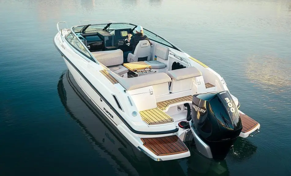 A sleek white motorboat with a Mercury engine, featuring plush seating and a scenic water backdrop.
